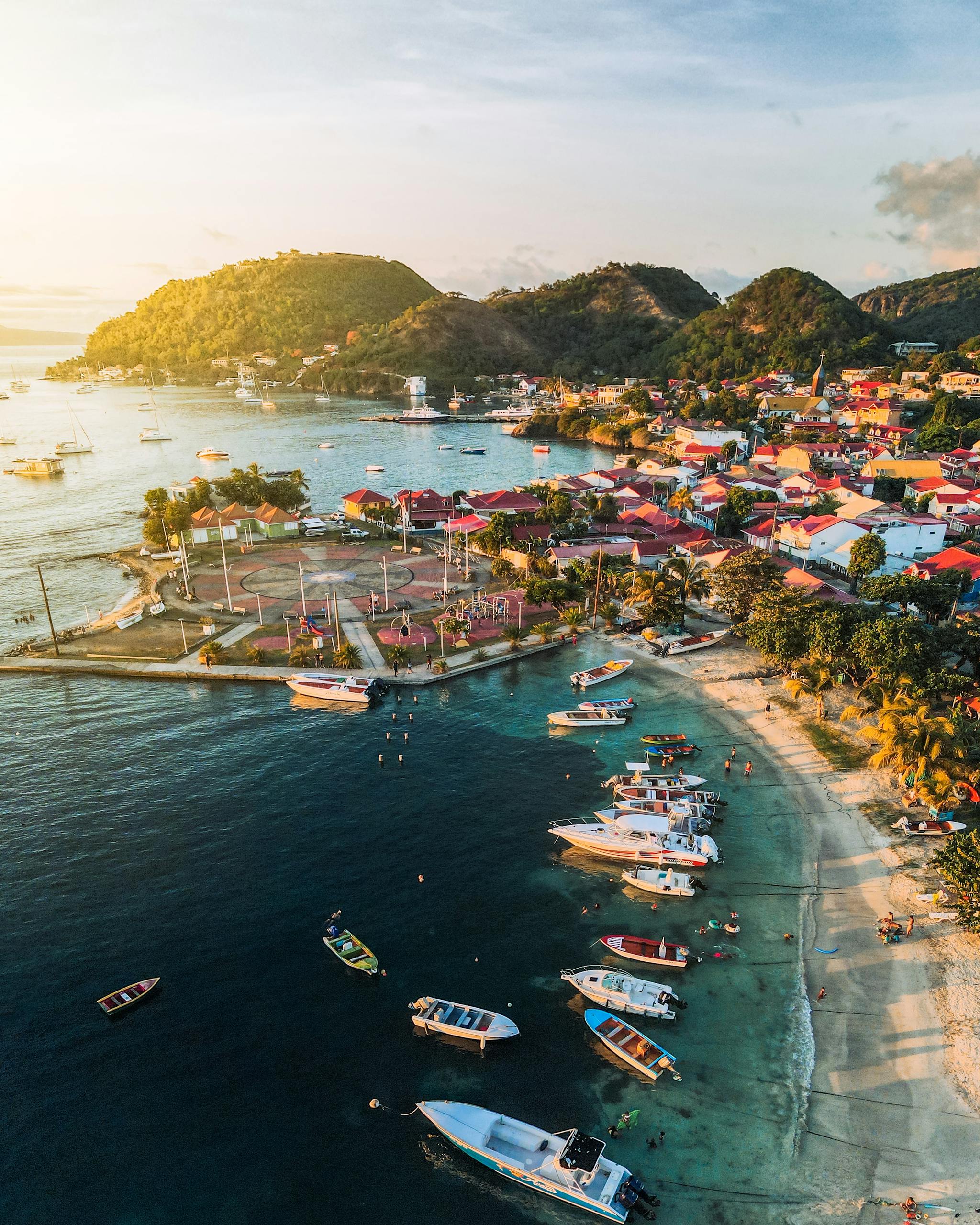 A stunning aerial view of a vibrant bay in Guadeloupe with boats and colorful buildings.